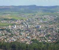 Vista panorâmica de Itabira, Minas Gerais, com morros ao fundo, em dia claro