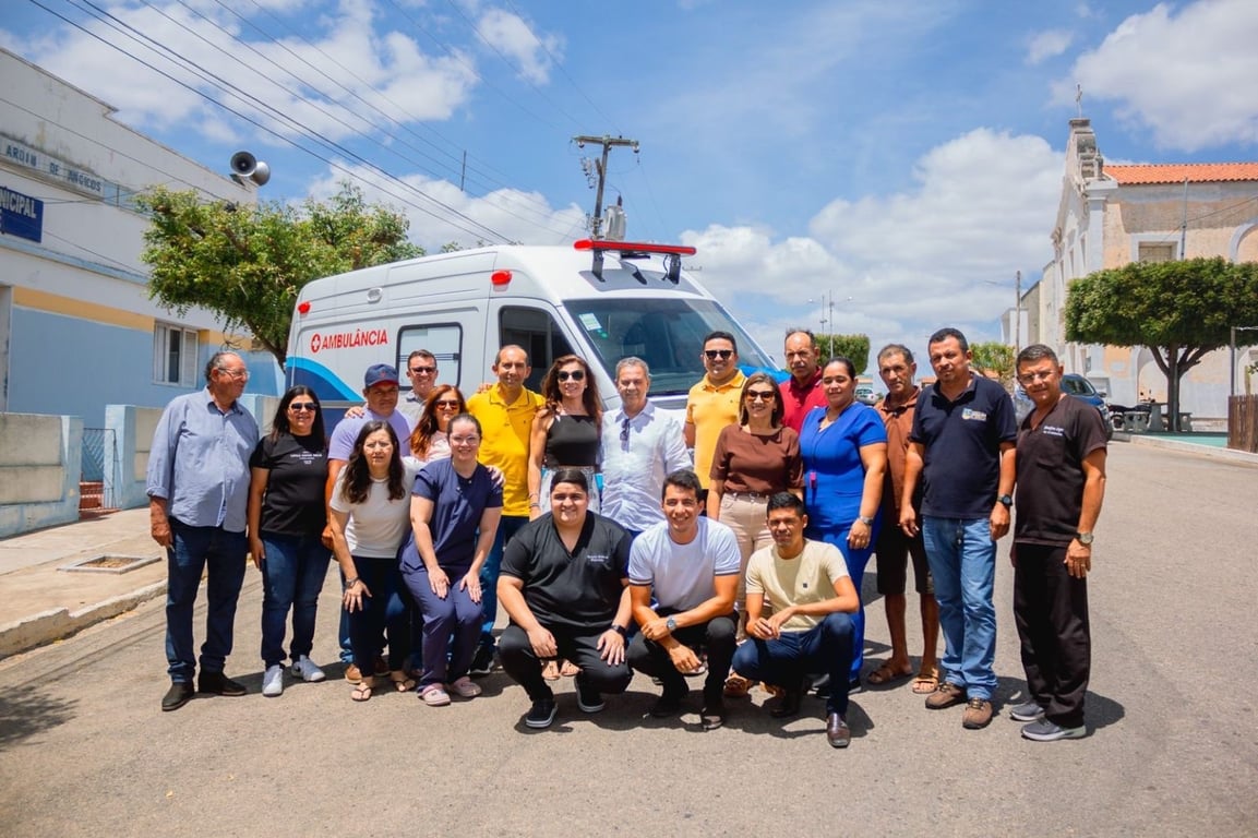 Ambulância estacionada em via urbana, com pessoas ao redor; foto horizontal, contexto de serviço de saúde