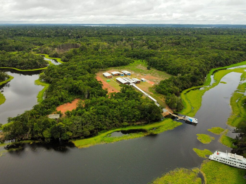Vista aérea de uma escola pública na Amazônia, cercada por vegetação