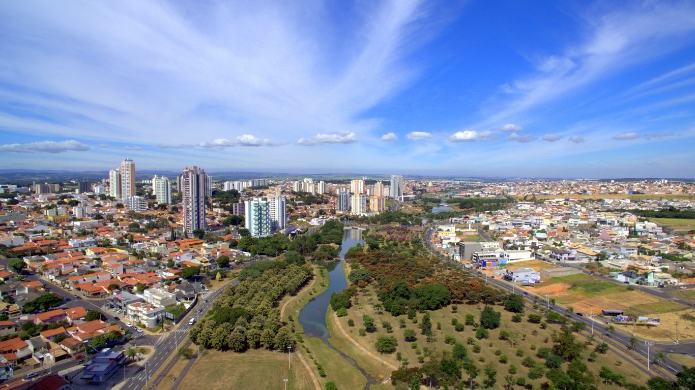 Vista aérea de cidade do interior paulista, com áreas verdes e céu azul