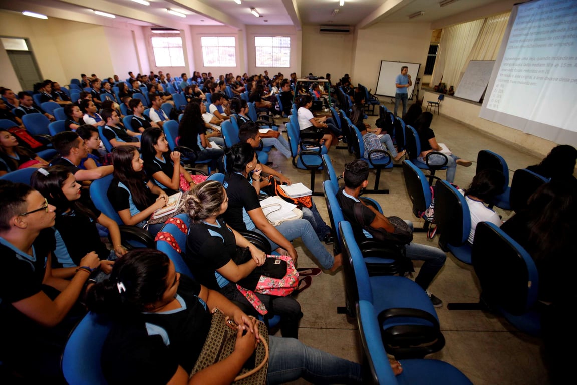 Sala de informática em escola pública, com estudantes assistindo a projeção em tela