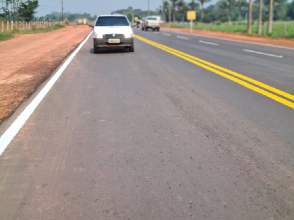 Rodovia estadual em Rondônia cercada por vegetação amazônica, com placa de sinalização