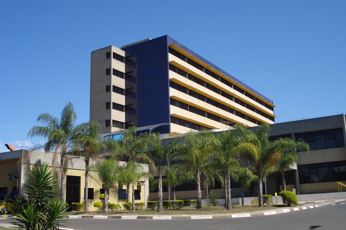 Fachada do Hospital Estadual de Sumaré (HES), com área verde e estrutura hospitalar em perspectiva horizontal.