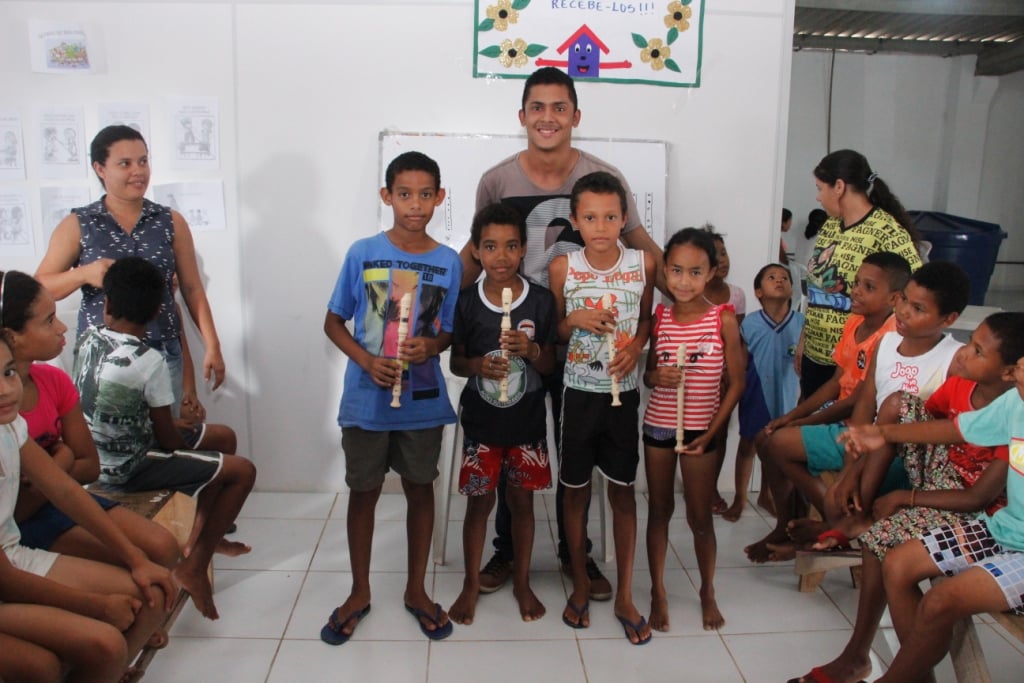 Atividade socioeducativa com crianças em centro comunitário, com educador conduzindo dinâmica