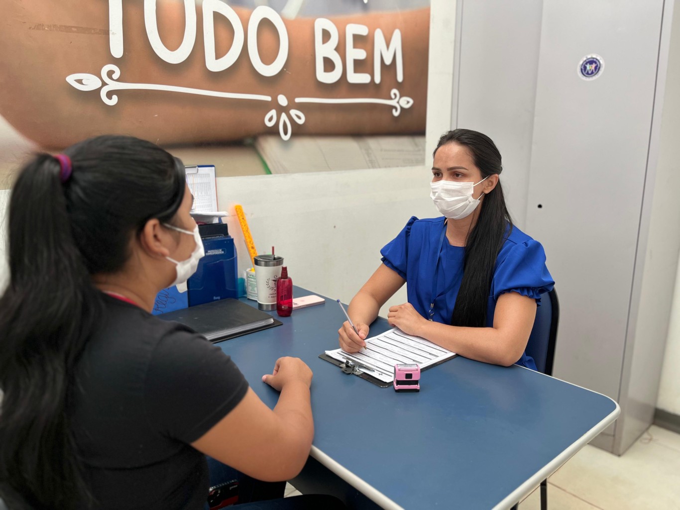 Atendimento em serviço público de assistência social, com profissional e usuário em conversa