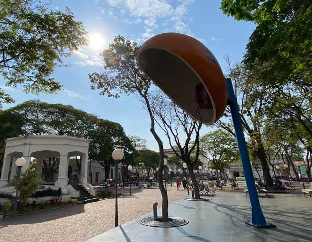 Praça central de Ibirá SP ao entardecer, com escultura e árvores