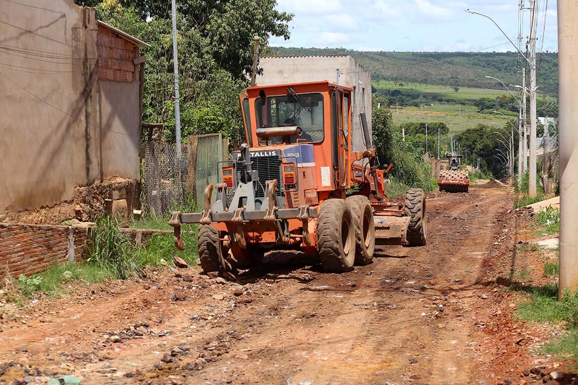 Motoniveladora e trator trabalhando em estrada de terra