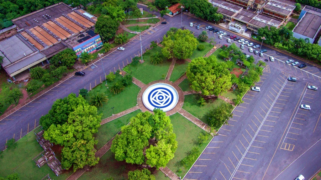 Vista aérea do campus da UFMT em Cuiabá, com áreas verdes e prédios acadêmicos ao fundo