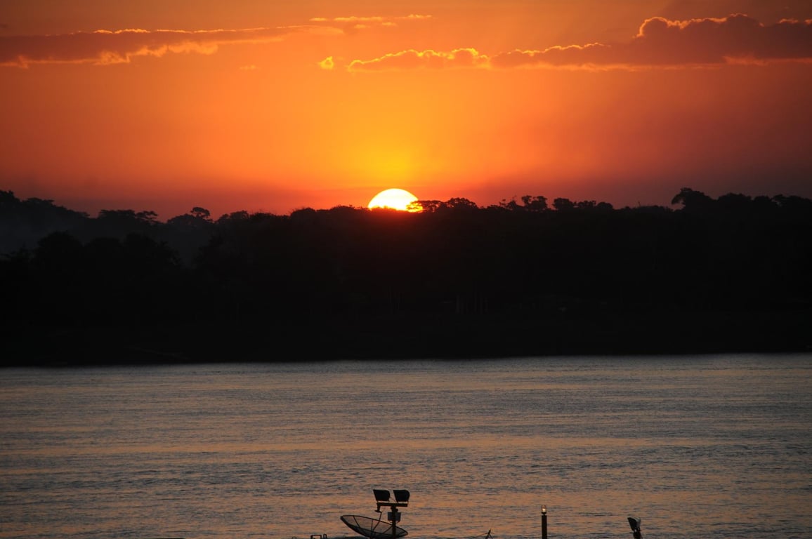 Pôr do sol sobre o Rio Madeira e a silhueta urbana de Porto Velho