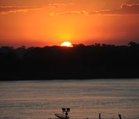 Pôr do sol sobre o Rio Madeira e a silhueta urbana de Porto Velho, sede da IDARON.