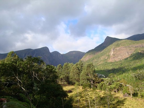 Vegetação de montanha e trilhas com montanhas ao fundo no Parque Nacional do Caparaó