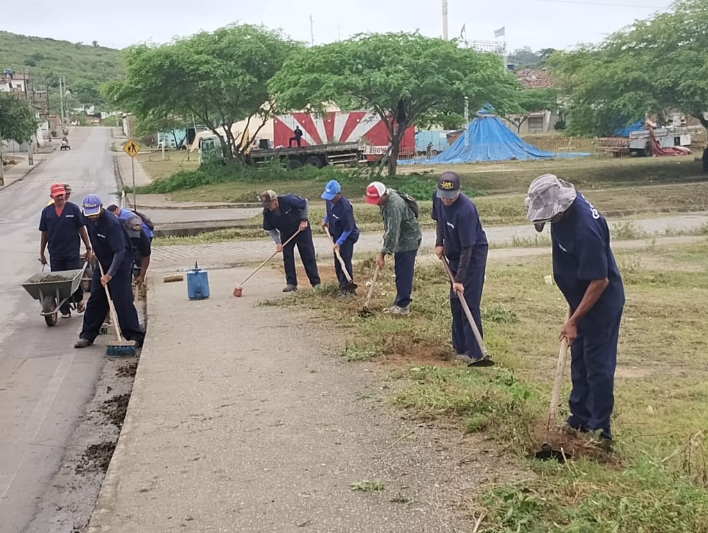 Servidores municipais em atividade de manutenção urbana, varrição e jardinagem