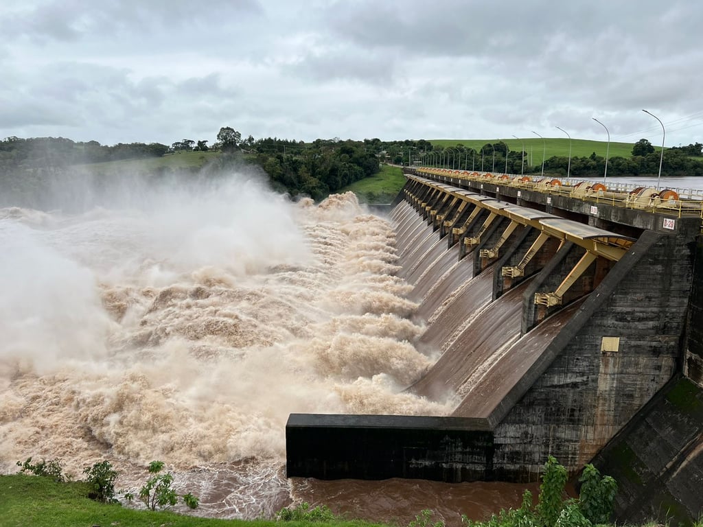 Vista aérea da Barragem de Passo Real, mostrando a estrutura da represa e o fluxo da água em um dia claro.