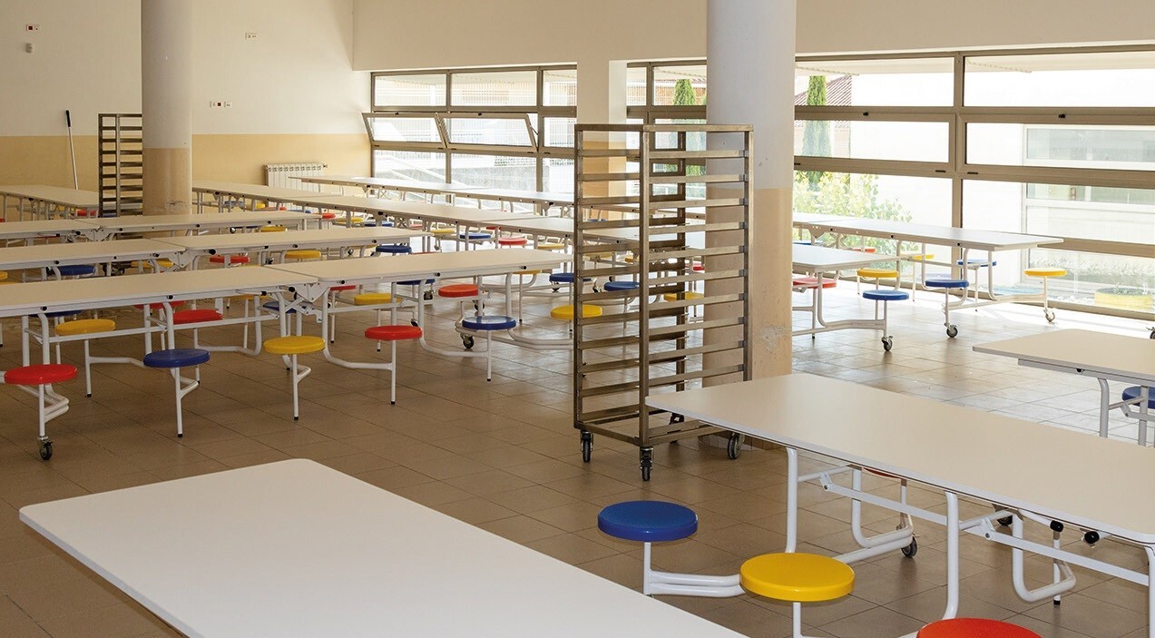 Ambiente de refeitório/cantina escolar com mesas organizadas e espaço limpo e iluminado