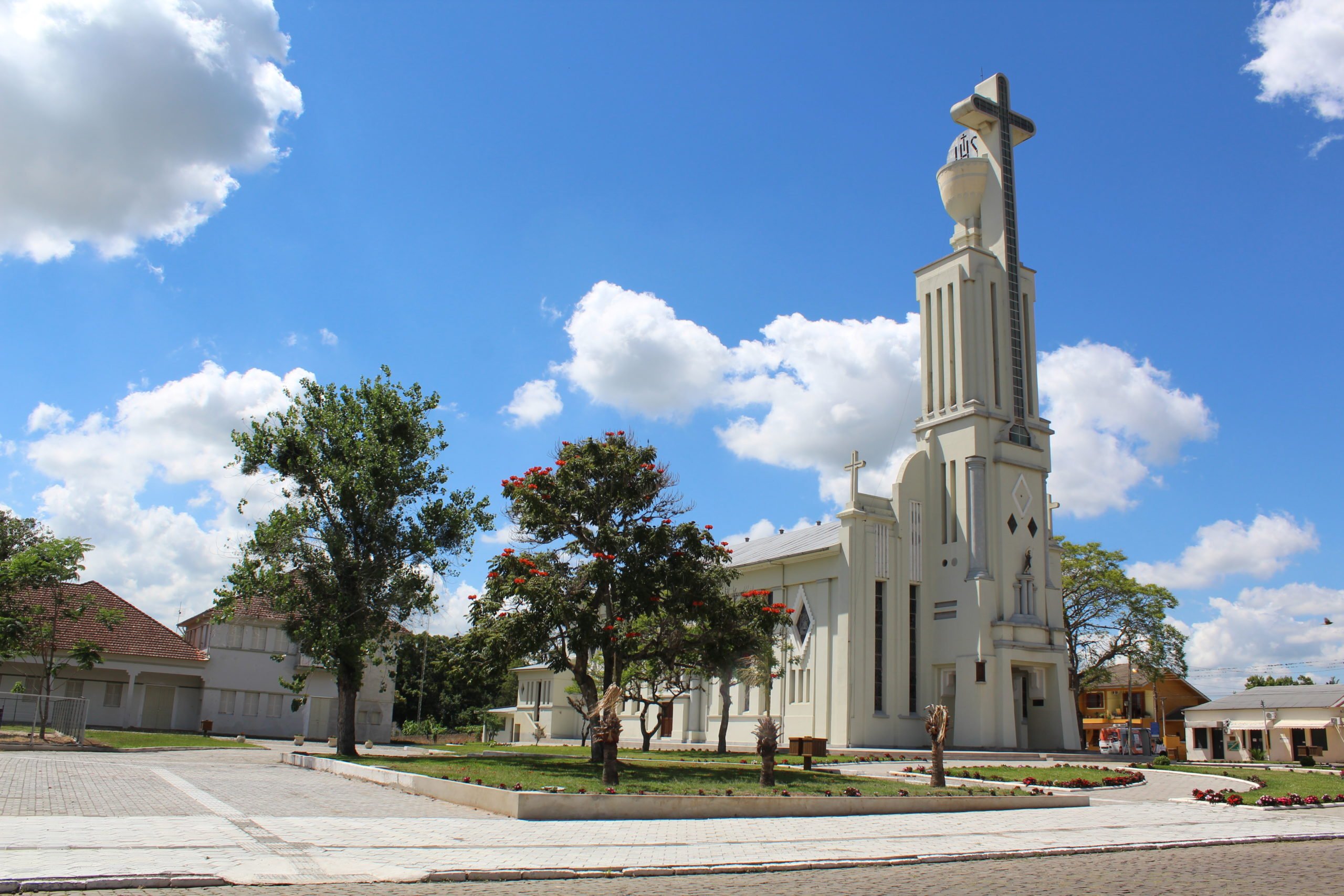 Vista urbana de Ivorá RS, com igreja, árvores e céu azul ao fundo