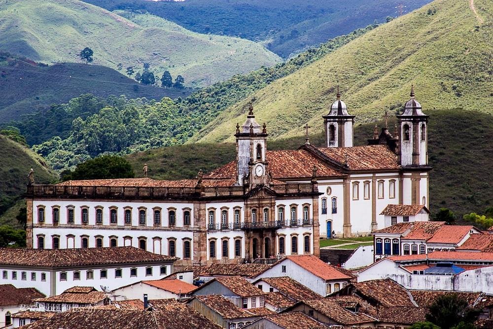 Vista panorâmica do centro histórico de Ouro Preto, com igrejas barrocas e morros ao fundo