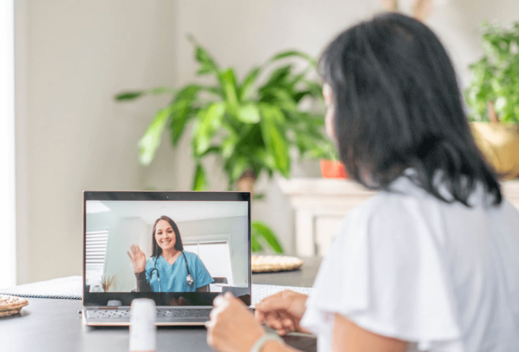 a patient talking to a healthcare professional on her laptop