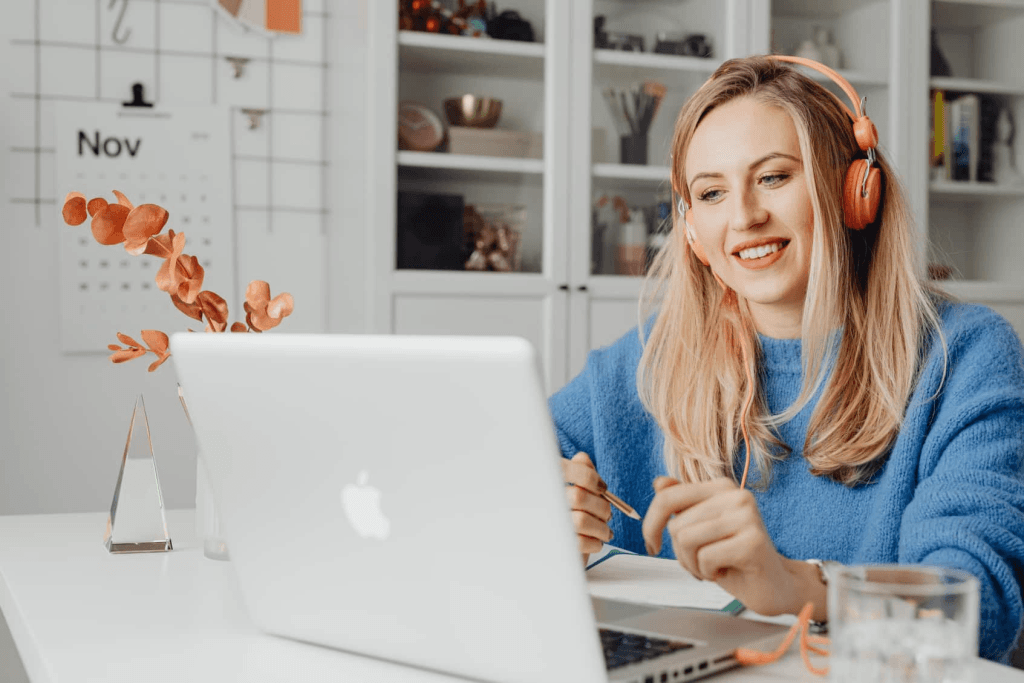 a virtual assistant smiling in front of her laptop