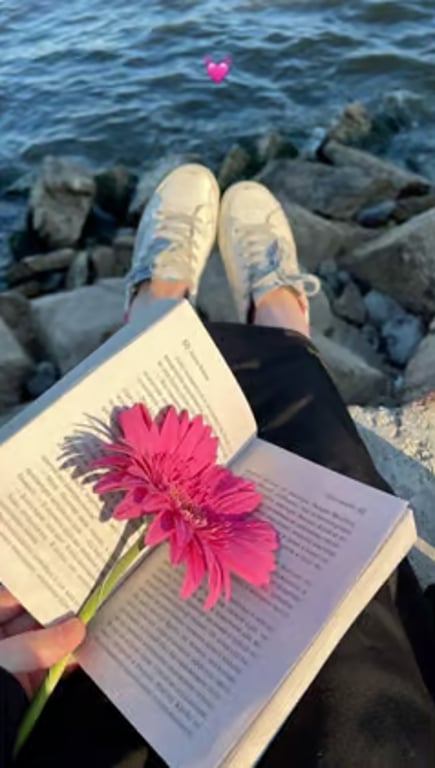 Student reading a book outdoors