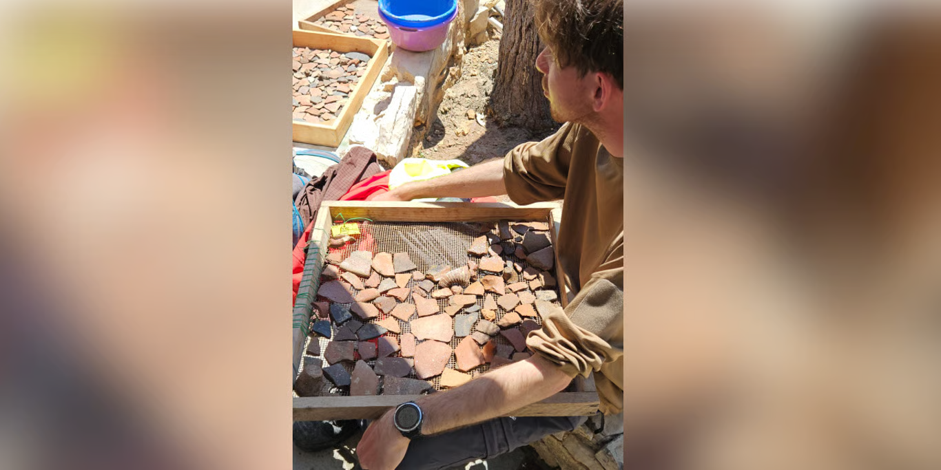 Student sorting archaeology finds on a field study