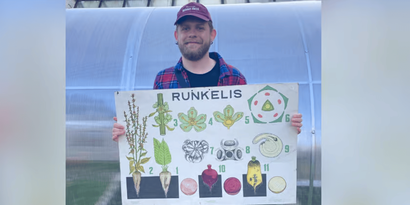 Student holding a botany teaching poster
