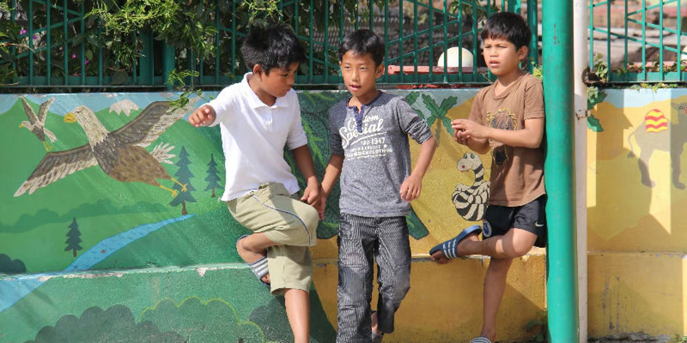 Children playing at a school wall mural