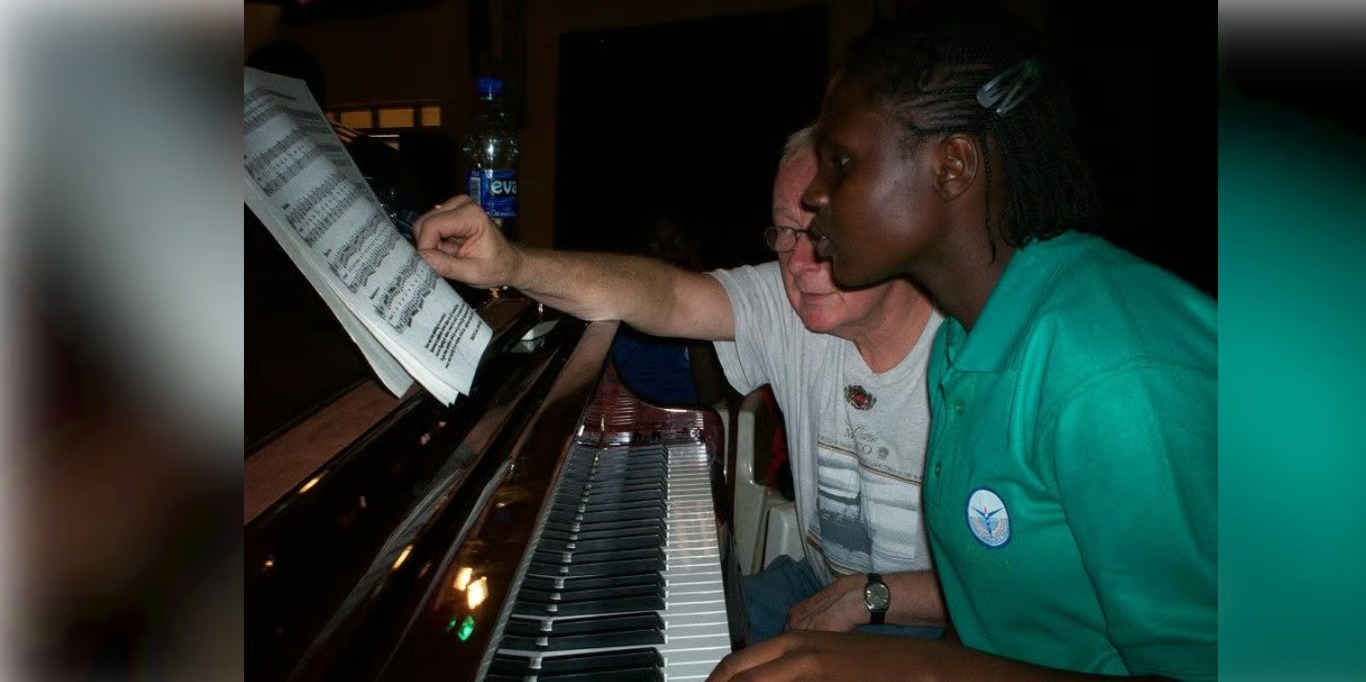Student learning piano with a volunteer teacher