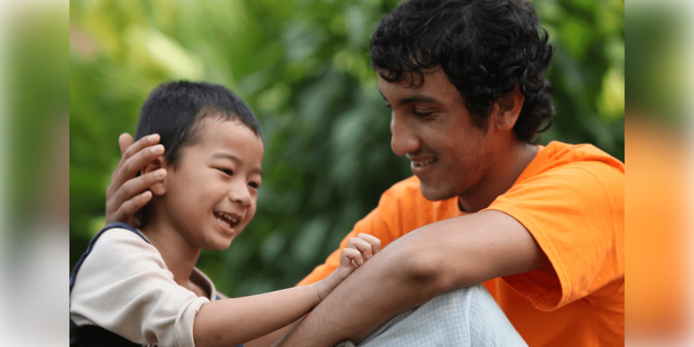 Volunteer mentor laughing with a young boy