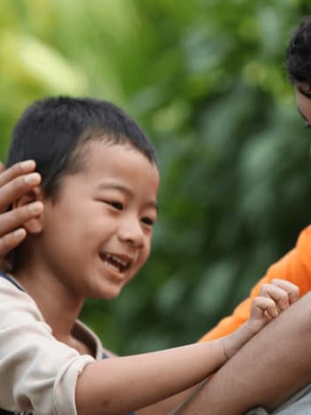 Volunteer mentor laughing with a young boy