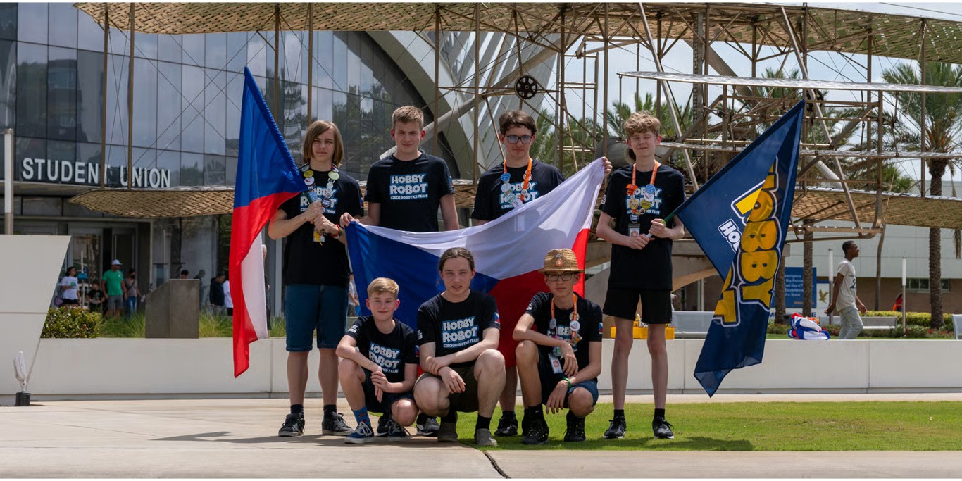Young robotics team with their national flag