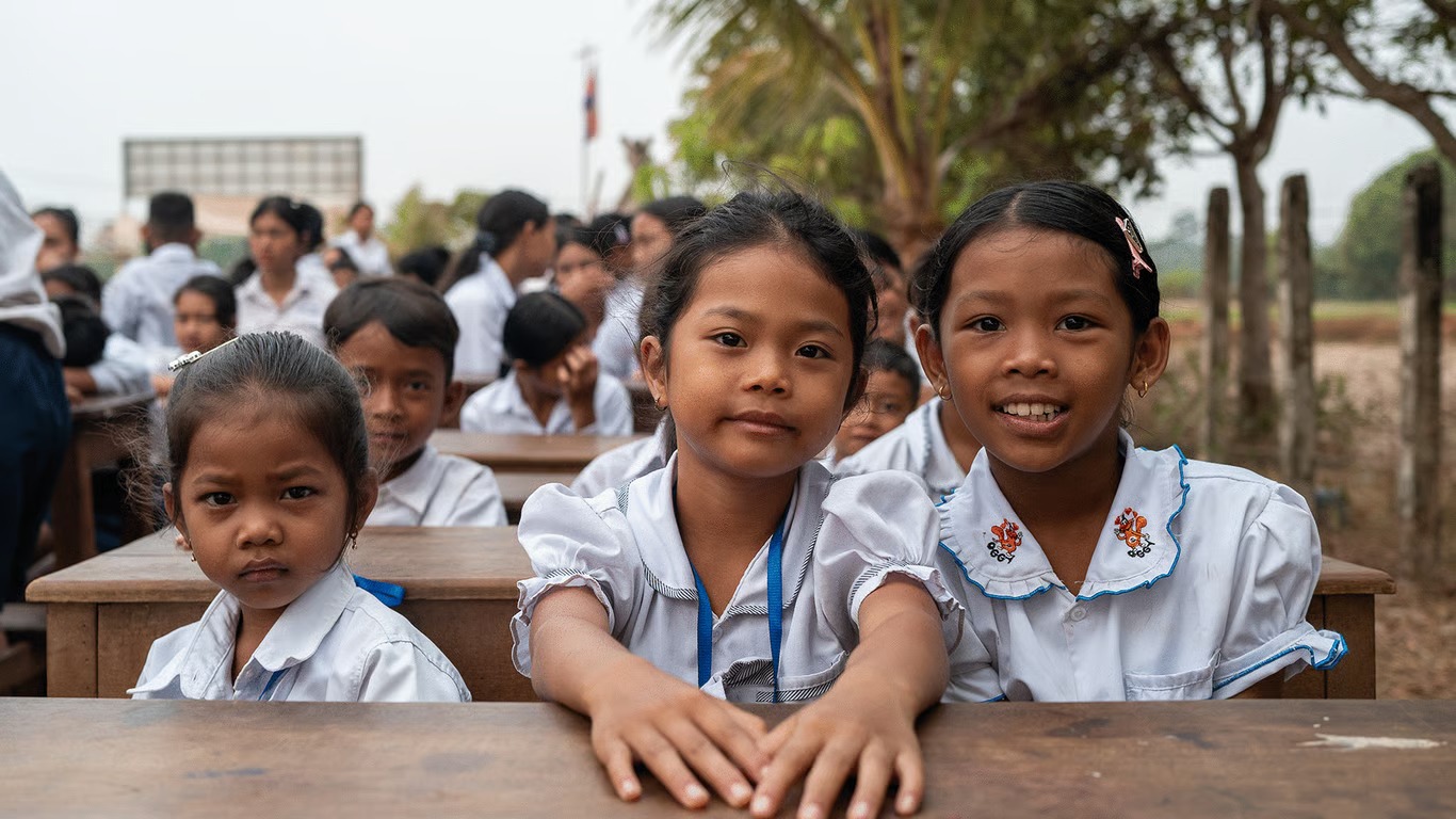 Schoolgirls smiling at their desks