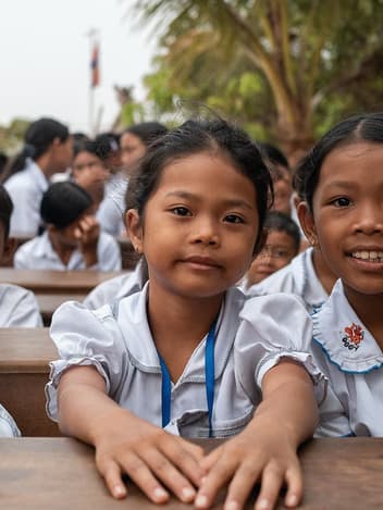Schoolgirls smiling at their desks