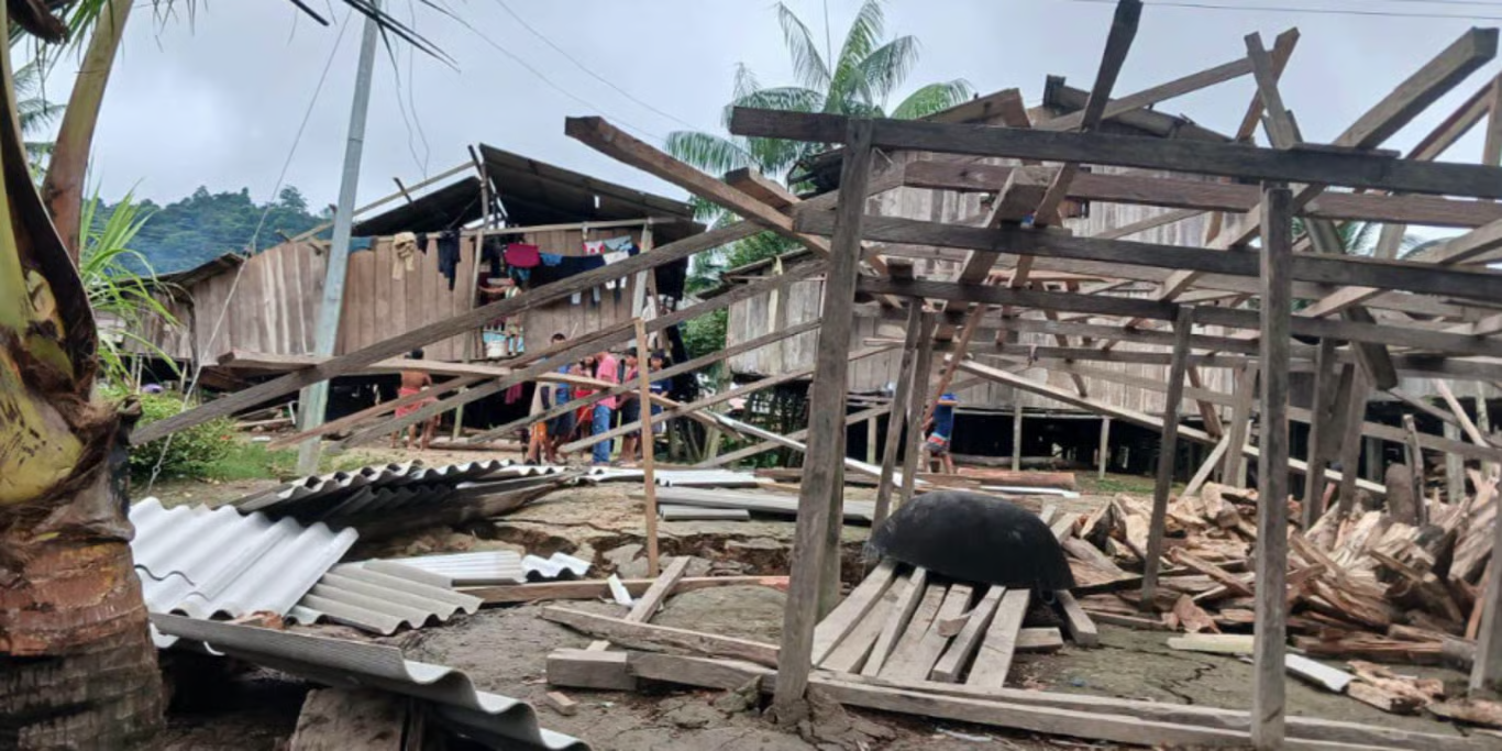 Wooden homes destroyed, timber and corrugated roofing scattered across the ground