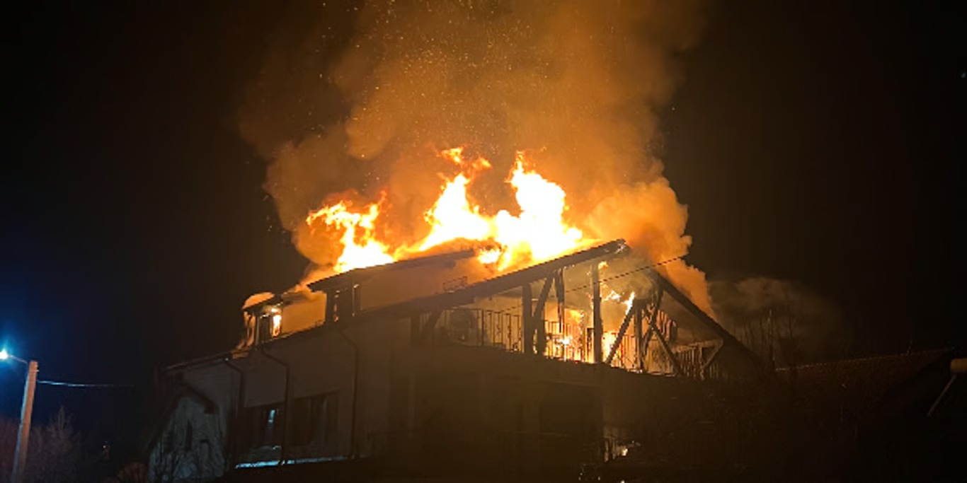 House engulfed in flames at night