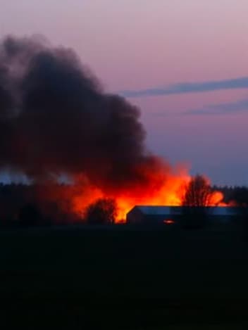 Barn on fire at dusk