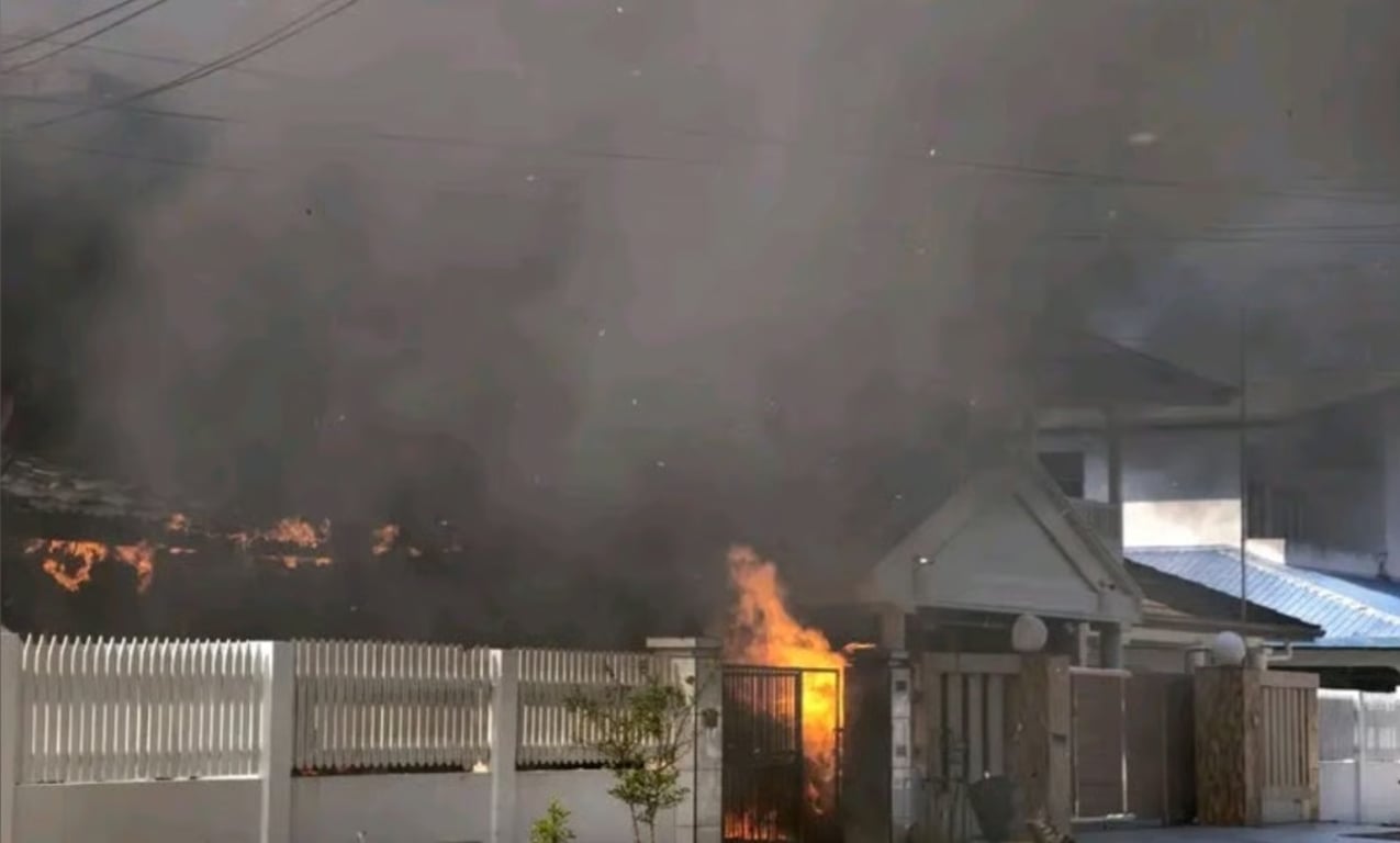 Smoke and flames behind a house gate