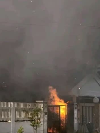 Smoke and flames behind a house gate