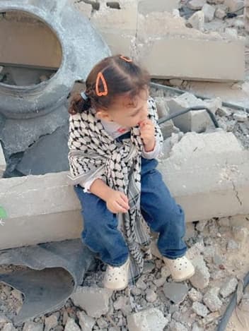 Little girl sitting on rubble