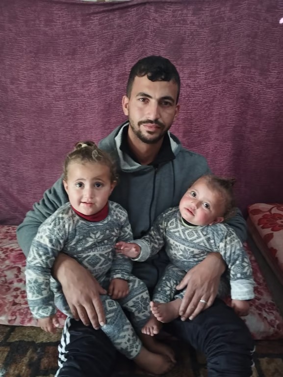 Father holding his twin daughters