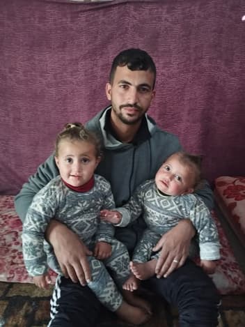 Father holding his twin daughters