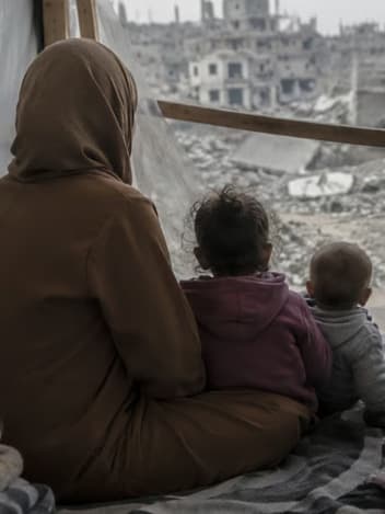 Mother and children looking out over a destroyed city