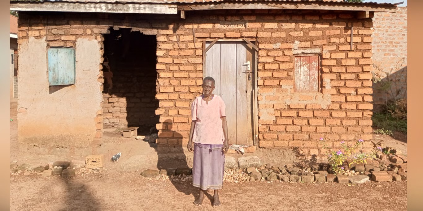 Woman standing outside her damaged home