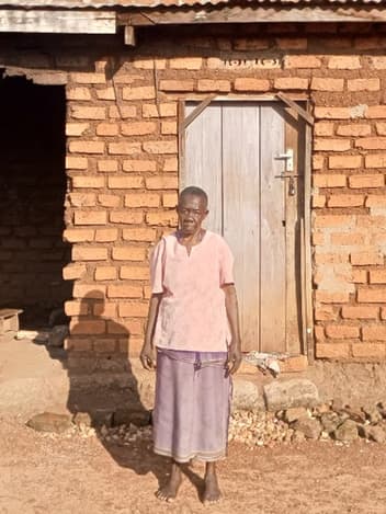 Woman standing outside her damaged home