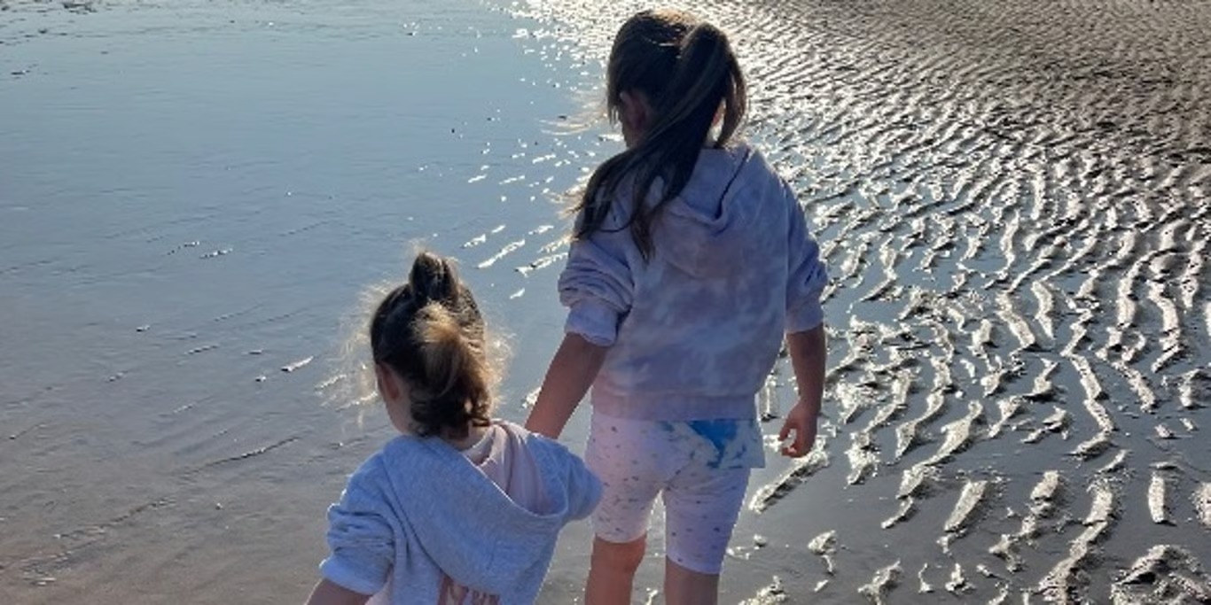 Two sisters walking along the beach