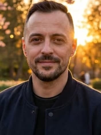 Man smiling in a park at sunset