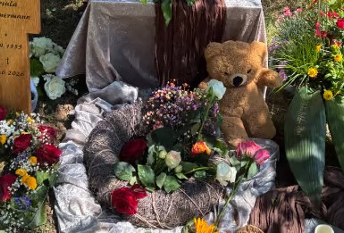 Flowers and a teddy bear at a graveside