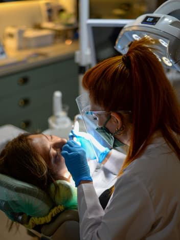 Dentist examining a patient under the lamp