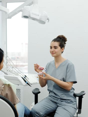 Dentist explaining a dental model to her patient
