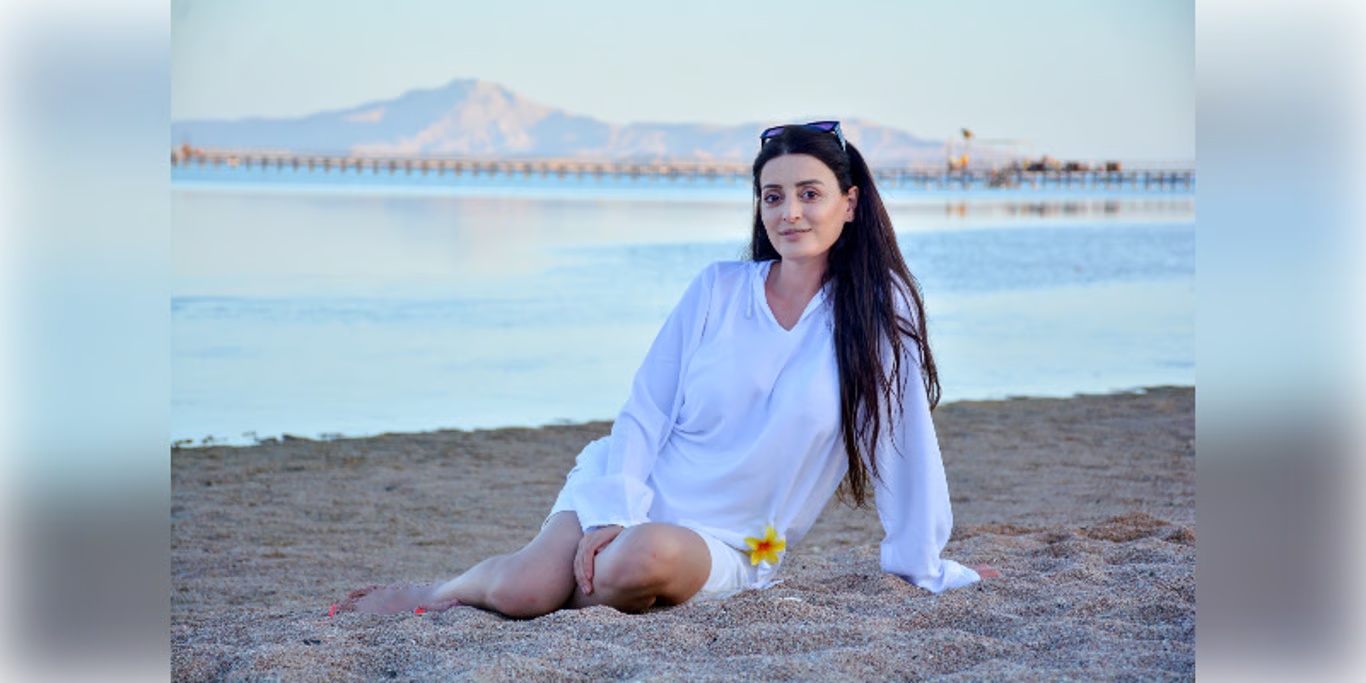 Woman sitting on the beach at sunset