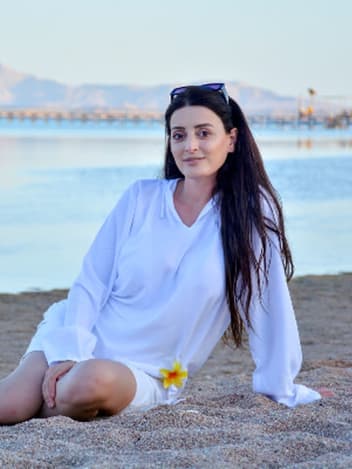 Woman sitting on the beach at sunset